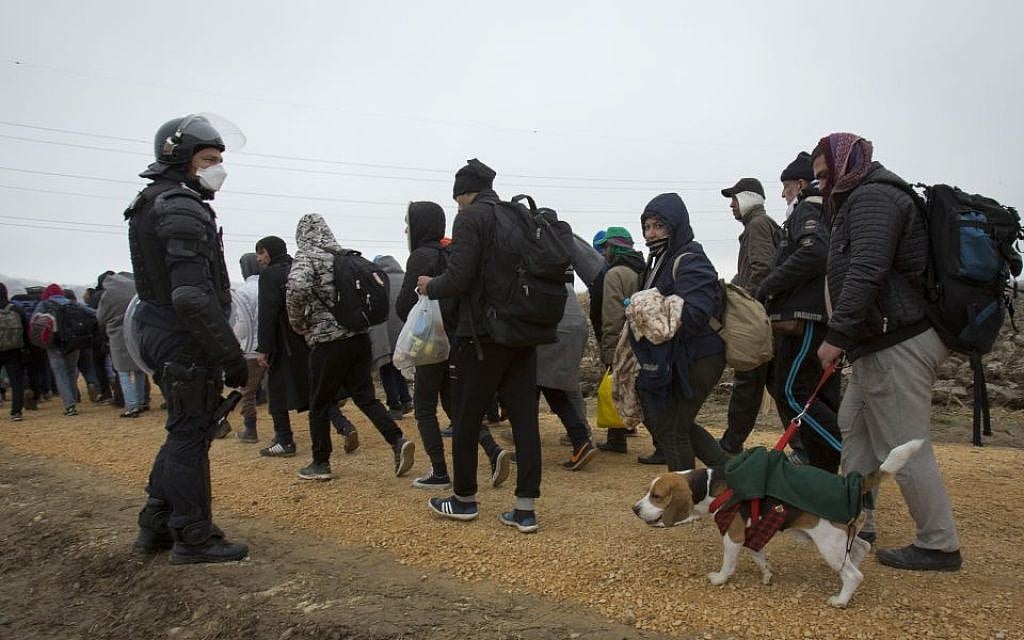 Mohamad Zaki from Baghdad, Iraq, walks his dog Ivo as he walks with a group of migrants after crossing from Croatia, in Rigonce, Slovenia, Sunday, Oct. 25, 2015. (AP Photo/Darko Bandic)