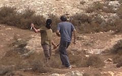 A masked right-wing extremist is seen attacking Arik Ascherman, head of Rabbis for Human Rights (YouTube screen grab)