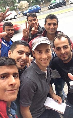 Some of the Syrian refugees interviewed in Berlin insisted on taking selfies with JTA’s Uriel Heilman, in Yankees cap. (Uriel Heilman/JTA)