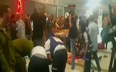 Paramedics treating victims after a terror attack at the Beersheba Central Bus Station on October 18, 2015. (screen capture: Channel 2)