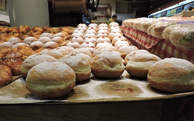 Sufganiyot on display in Jerusalem’s Central Bus Station. The jelly doughnut began appearing in bakeries around Israel more than a month before Hanukkah. (Ben Sales) Sufganiyot on display in Jerusalem’s Central Bus Station. The jelly doughnut began appearing in bakeries around Israel more than a month before Hanukkah. (Ben Sales)