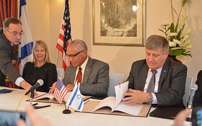 NASA Administrator Charles Bolden (center) and Israel Space Agency Director General Menachem Kidron (right) sign cooperation agreement at the International Astronautical Congress held in Jerusalem, October 13, 2015 (Photo by Yair Zrika)