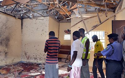 A picture taken on October 23, 2015 in Maiduguri, northeast Nigeria, shows people standing in a mosque following a suicide bombing. (AFP/STRINGER)