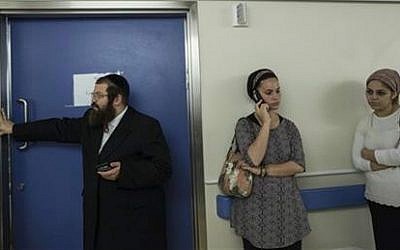 In this Monday, Oct. 12, 2015 photo, friends and relatives of Odel Bennett stand outside her room at the Hadassah Medical Center in Jerusalem (Tsafrir Abayov) In this Monday, Oct. 12, 2015 photo, friends and relatives of Odel Bennett stand outside her room at the Hadassah Medical Center in Jerusalem (AP Photo/Tsafrir Abayov)