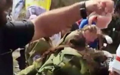 Kiryat Arba resident places pig flesh on the body of a Palestinian terrorist after a stabbing attack in Kirayt Arba, October 9, 2015. (Screenshot from YouTube)