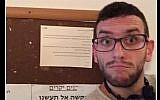 An Arab resident of Tel Aviv takes a selfie in front of an anti-Arab notice hung in his building's stairwell on October 12, 2015. (Screen shot: Facebook)