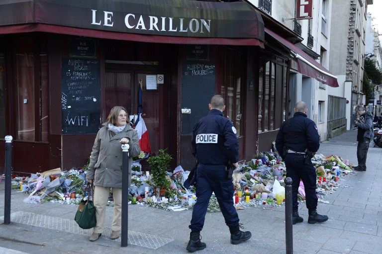 Police officers walk past flowers, notes and candles at a memorial site outside of the Carillon bar, in the 10th district of Paris, for victims of the November 13 terrorist attacks in Paris, November 15, 2015. (Photo by AFP Photo / Bertrand Guay) Police officers walk past flowers, notes and candles at a memorial site outside of the Carillon bar, in the 10th district of Paris, for victims of the November 13 terrorist attacks in Paris, November 15, 2015. (Photo by AFP Photo / Bertrand Guay)