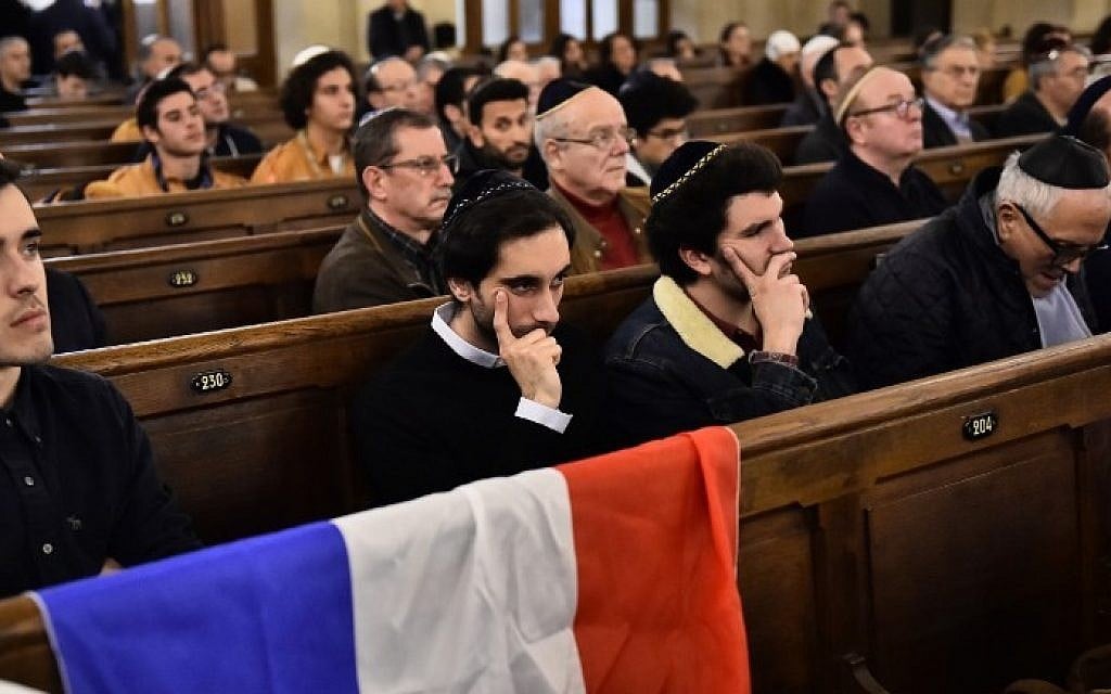 People sit near a French flag as they attend a ceremony for the victims of a series of deadly attacks at the Grande synagogue de la Victoire on November 15, 2015. (Loic Venance/AFP) People sit near a French flag as they attend a ceremony for the victims of a series of deadly attacks at the Grande synagogue de la Victoire on November 15, 2015. (Loic Venance/AFP)