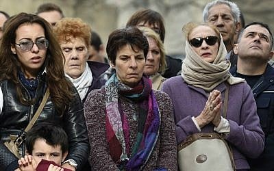 People observe a minute of silence on November 16, 2015 in front of the Le Carillon cafe in Paris, to pay tribute to victims of the attacks claimed by Islamic State which killed at least 129 people and left more than 350 injured on November 13. (AFP Photo/Lionel Bonaventure)