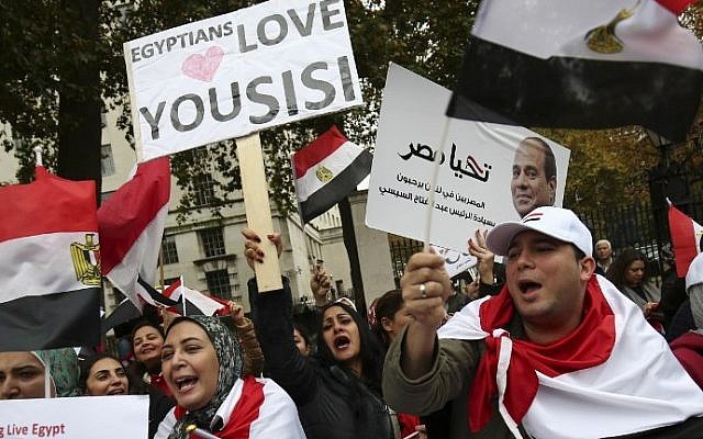 A supporter (C) welcoming the expected visit of Egyptian President Abdel Fattah el-Sissi holds a placard as other supporters wave Egyptian flags outside Downing Street in central London on November 5, 2015. (AFP PHOTO / JUSTIN TALLIS) A supporter (C) welcoming the expected visit of Egyptian President Abdel Fattah el-Sissi holds a placard as other supporters wave Egyptian flags outside Downing Street in central London on November 5, 2015. (AFP PHOTO / JUSTIN TALLIS)