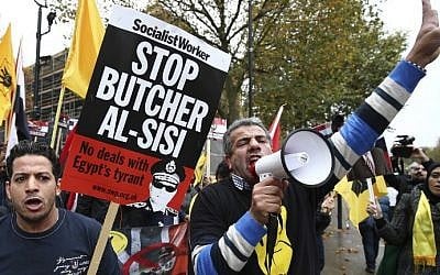 Protesters against the expected visit of Egyptian President Abdel Fattah al-Sisi shout slogans and wave placards and flags showing the four finger symbol known as "Rabaa", meaning four in Arabic, which is associated with those killed in the crackdown on the Rabaa al-Adawiya protest camp in Cairo in 2013, outside Downing Street in central London on November 5, 2015.(AFP PHOTO / JUSTIN TALLIS)