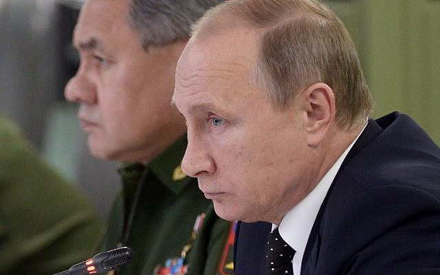 Russian President Vladimir Putin (front), accompanied by Defense Minister Sergei Shoigu, meets with top military officials at the National Defense Control Center of the Russian Federation in Moscow on November 17, 2015. (AFP PHOTO / SPUTNIK / ALEXEI NIKOLSKY)