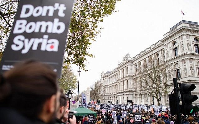 Demonstrators hold placards as they protest outside the entrance to Downing Street in central London on November 28, 2015, against the British government's proposed involvement in air strikes against the Islamic State group in Syria. (AFP/Leon Neal) Demonstrators hold placards as they protest outside the entrance to Downing Street in central London on November 28, 2015, against the British government's proposed involvement in air strikes against the Islamic State group in Syria. (AFP/Leon Neal)