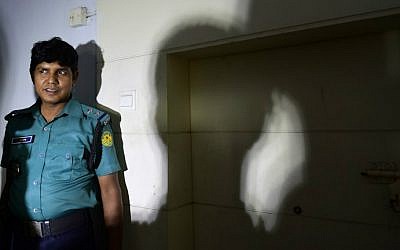 A Bangladeshi policeman stands guard at the office where publisher Ahmedur Rashid Chowdhury Tutul, blogger Tarik Rahim and writer Ranadipam Basu were attacked in Dhaka on October 31, 2015. (AFP Photo/Munir uz Zaman)