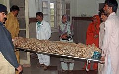 Pakistani relatives carry the body of young woman who died after being set on fire by a rejected suitor, in a hospital in Multan on November 3, 2015. (SS Mirza/AFP)
