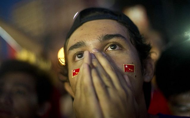 A supporter of Myanmar opposition leader Aung San Suu Kyi celebrate as they look at the official election results outside the National League of Democracy headquarters in Yangon on November 9, 2015. (Photo by AFP Photo / Ye Aung Thu)