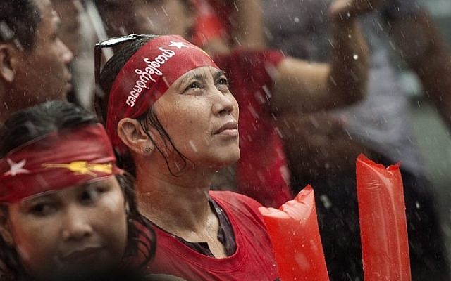 Supporters of Myanmar opposition leader Aung San Suu Kyi brave the rain as they celebrate after hearing the first official results of the elections on November 9, 2015. (AFP PHOTO / Nicolas ASFOURI) Supporters of Myanmar opposition leader Aung San Suu Kyi brave the rain as they celebrate after hearing the first official results of the elections on November 9, 2015. (AFP PHOTO / Nicolas ASFOURI)
