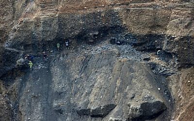 This photo taken on October 4, 2015 shows freelance miners digging for raw jade stones in piles of waste rubble dumped by mechanical diggers, next to a jade mine in Hpakant, Myanmar's Kachin State. Around 90 people were killed in a huge landslide as they picked through mountains of waste rubble in a remote mining area of northern Myanmar searching for precious jade, officials reported on November 22, 2015.      (AFP PHOTO/Ye Aung THU)