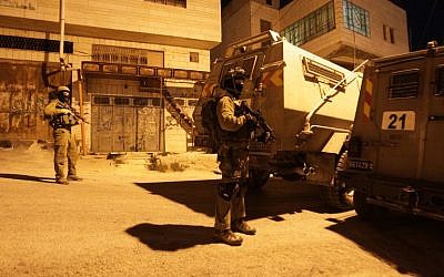 Illustrative: IDF soldiers stand guard in the West Bank, June 15, 2014. (AFP/Hazem Bader)