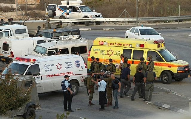 File: Israeli security forces and emergency personnel gather at the site of a reported car-ramming attack on Israeli Border Policemen at the Beit Anun junction, north of the West Bank city of Hebron, on November 1, 2015. (AFP/Hazem Bader)