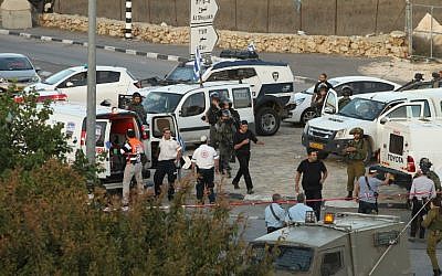Israeli security forces and emergency personnel gather at the site of a reported car-ramming attack on Border Police at the Beit Einun junction, north of the West Bank city of Hebron, on November 1, 2015. (AFP/Hazem Bader)