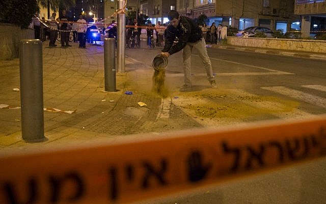 A member of the Israeli security forces cleans off the blood at the scene of a stabbing attack carried out by a Palestinian man in the Israeli city coastal city of Netanya on November 2, 2015 (AFP PHOTO / JACK GUEZ)