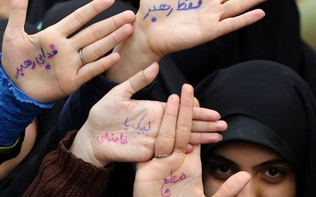 Iranian women show their palms with slogans praising the Iranian supreme leader Ayatollah Ali Khamenei written on them, outside the former US embassy in the Iranian capital Tehran during a demonstration marking the anniversary of its storming by student protesters that triggered a hostage crisis in 1979, November 4, 2015. (Photo by AFP Photo / Atta Kenare)
