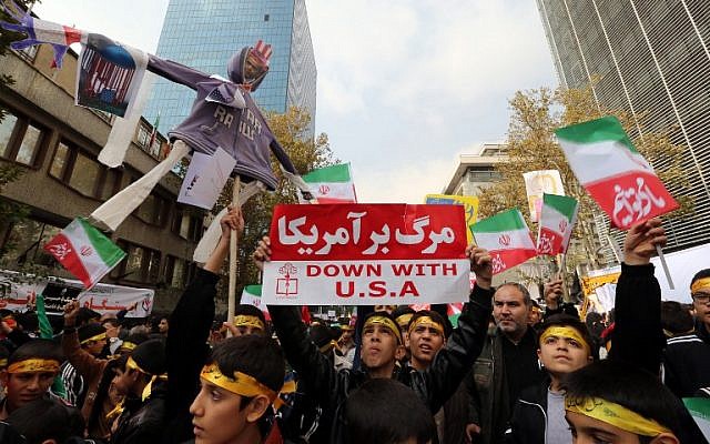 Iranian teenagers carry banners and national flags outside the former US embassy in the Iranian capital Tehran during a demonstration marking the anniversary of its storming by student protesters that triggered a hostage crisis in 1979, November 4, 2015. (Photo by AFP Photo / Atta Kenare)