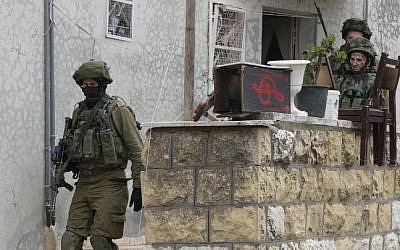 Israeli soldiers search a Palestinian home in the West Bank town of Hebron, November 7, 2015. (AFP/Hazem Bader, File)