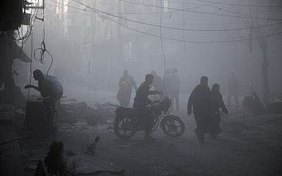 Syrians walk in a dusty street following air strikes by suspected Russian planes on the central rebel-held town of Douma, on the outskirts of the capital Damascus, on November 7, 2015. (AFP/ABD DOUMANY)