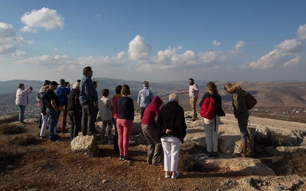 Nati Rom, chairman of Lev Haolam foundation, guides a group European Christians during a tour of the Israeli outpost of Esh Kodesh in the West Bank on November 10, 2015. (Menahem Kahana/AFP) Nati Rom, chairman of Lev Haolam foundation, guides a group European Christians during a tour of the Israeli outpost of Esh Kodesh in the West Bank on November 10, 2015. (Menahem Kahana/AFP)