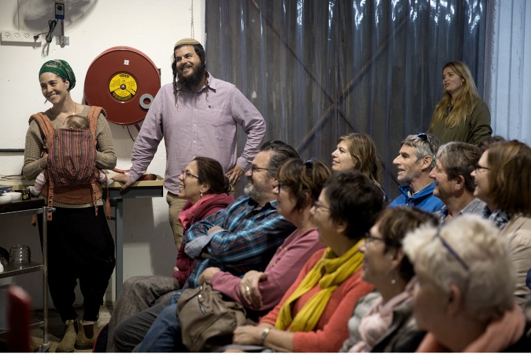 Nati Rom (C standing) chairman of Lev Haolam foundation and European Christian Dutch activist Arjanne Kloos (R standing) smile during a visit to the Israeli settlement of Esh Kodesh in the West Bank on November 10, 2015. (Menahem Kahana/AFP) Nati Rom (C standing) chairman of Lev Haolam foundation and European Christian Dutch activist Arjanne Kloos (R standing) smile during a visit to the Israeli settlement of Esh Kodesh in the West Bank on November 10, 2015. (Menahem Kahana/AFP)