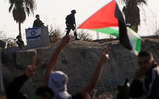 Palestinian protesters wave their national flag during clashes with members of the Israeli security forces in the West Bank city of Tulkarem on November 12, 2015. (Jaafar Ashtiyeh/AFP) Palestinian protesters wave their national flag during clashes with members of the Israeli security forces in the West Bank city of Tulkarem on November 12, 2015. (Jaafar Ashtiyeh/AFP)