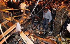 Emergency personnel inspect the debris at the site of a twin suicide bombing in Burj al-Barajneh, in the southern suburbs of the capital Beirut on November 12, 2015. (AFP Photo/Anwar Amro)