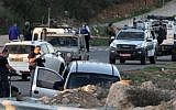 Israeli soldiers and police inspect a car following a deadly attack near the settlement of Otniel, south of the West Bank city of Hebron, on November 13, 2015. (AFP/Hazem Bader)