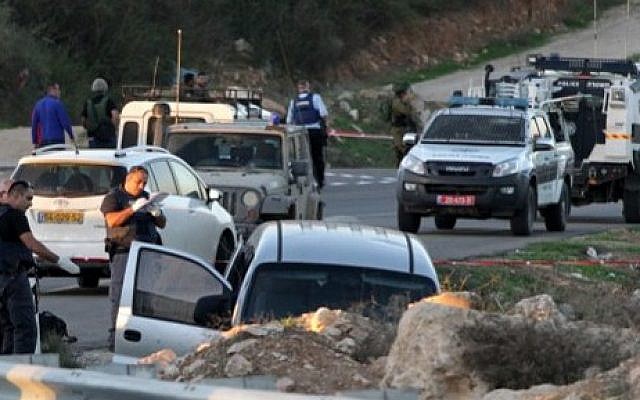 Israeli soldiers and police inspect a car following a deadly attack near the settlement of Otniel, south of the West Bank city of Hebron, on November 13, 2015. (AFP/Hazem Bader) Israeli soldiers and police inspect a car following a deadly attack near the settlement of Otniel, south of the West Bank city of Hebron, on November 13, 2015. (AFP/Hazem Bader)