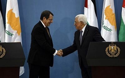 Cypriot President Nicos Anastasiades and PA President Mahmoud Abbas shake hands during a joint press conference in the West Bank city of Ramallah on November 13, 2015. AFP PHOTO/POOL/ALAA BADARNEH)