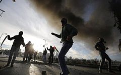 Illustrative: Palestinians throw stones at Israeli security forces during clashes in the Palestinian town of al-Bireh on the outskirts of Ramallah on November 20, 2015. (AFP Photo/Abbas Momani)