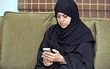 A picture taken on November 26, 2015 shows Nassima al-Sadah, a candidate for municipal councils in the Gulf coast city of Qatif, checking her phone at her office in Qatif 400 kilometers east of the Saudi capital, Riyadh. (AFP/STR)