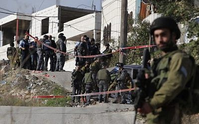 A member of the Israeli security forces stands guard at the site of a car-ramming attack that injured six IDF soldiers near Hebron on November 27, 2015. (AFP PHOTO/HAZEM BADER)