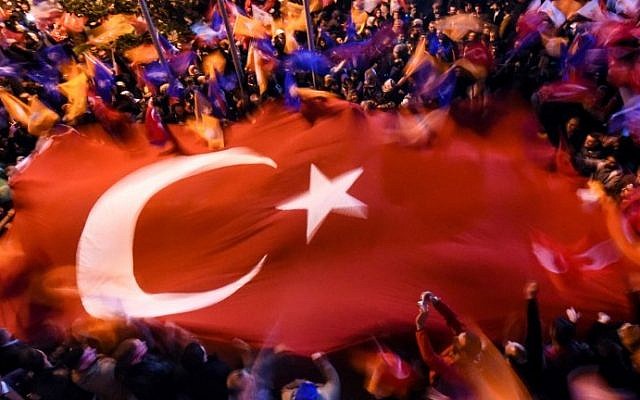 Supporters of Turkey's Justice and Development Party (AKP) wave a giant Turkish flag as they celebrate in Istanbul after the first results in the country's general election on November 1, 2015. (AFP PHOTO / OZAN KOSE)
