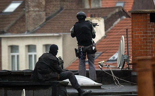 Special force officers stand guard on a roof top near the scene of a police raid in Rue Delaunoy, in the district of Molenbeek, in Brussels on November 16, 2015. (AFP PHOTO/BELGA/DIRK WAEM) Special force officers stand guard on a roof top near the scene of a police raid in Rue Delaunoy, in the district of Molenbeek, in Brussels on November 16, 2015. (AFP PHOTO/BELGA/DIRK WAEM)