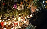 A woman lights candles at a makeshift memorial next to the Bataclan concert hall on November 16, 2015, in Paris. (AFP/ BERTRAND GUAY)