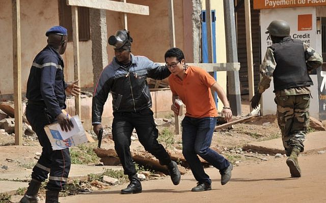Malian security forces evacuate a man from an area surrounding the Radisson Blu Hotel in Bamako on November 20, 2015. (AFP/Habibou Kouyate) Malian security forces evacuate a man from an area surrounding the Radisson Blu Hotel in Bamako on November 20, 2015. (AFP/Habibou Kouyate)
