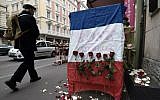 A man walks past a French national flag put outside a flower shop on November 27, 2015 in Strasbourg, eastern France, in tribute to the 130 people killed in the November 13 Paris attacks. (AFP Photo/Frederick Florin)