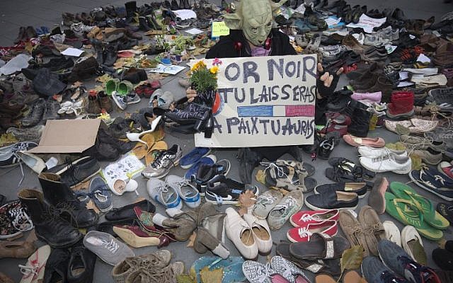 A man dressed as Yoda stands among shoes on the Place de la Republique which is covered in pairs of shoes on November 29, 2015 in downtown Paris (AFP PHOTO / JOEL SAGET / AFP / JOEL SAGET)