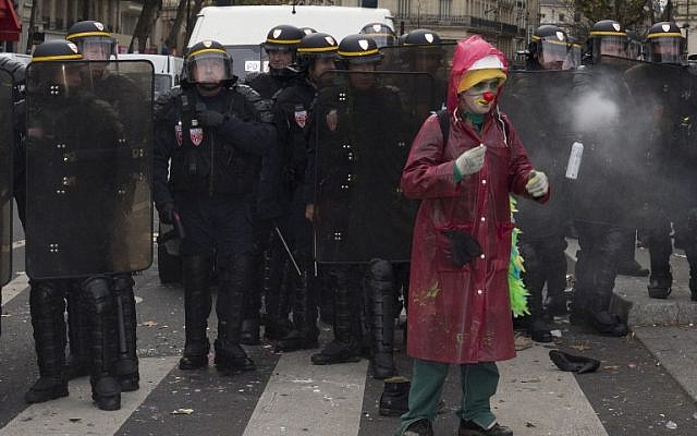 A protestor disguised as a clown stands in front of riot police during clashes following a rally against global warming on November 29, 2015 in Paris (AFP PHOTO / JOEL SAGET / AFP / JOEL SAGET)