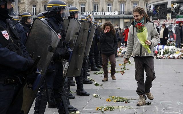 A protestors places flowers on the ground during a rally against global warming on November 29, 2015 in Paris, a day ahead of the start of UN conference on climate change COP21. (AFP PHOTO / FLORIAN DAVID / AFP / FLORIAN DAVID)