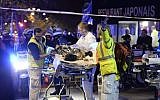 Rescuers evacuate an injured person near the Bataclan concert hall in central Paris, early on November 14, 2015. (AFP PHOTO/MIGUEL MEDINA)