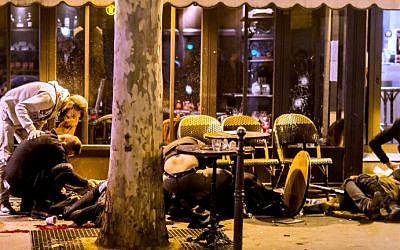 People lie on the pavement at Cafe Bonne Biere in Paris, on November 13, 2015, following a series of coordinated attacks in and around Paris which left more than 120 people dead. (AFP PHOTO / ANTHONY DORFMANN)